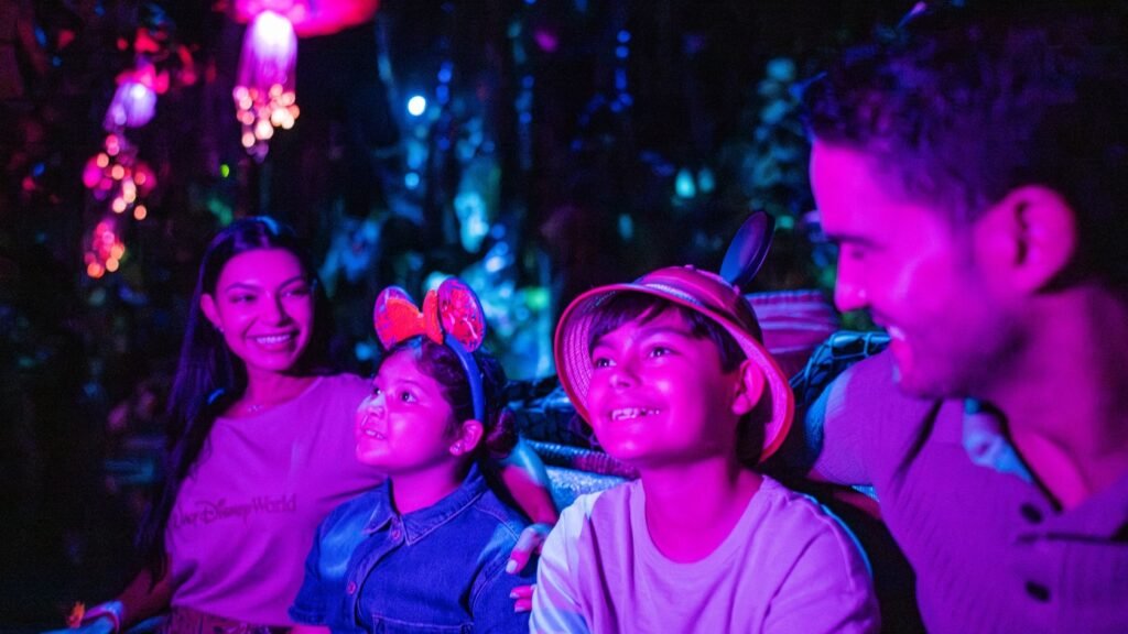 A family of 4 smiling while traveling through the Navi River Journey attraction in Disney’s Animal Kingdom theme park