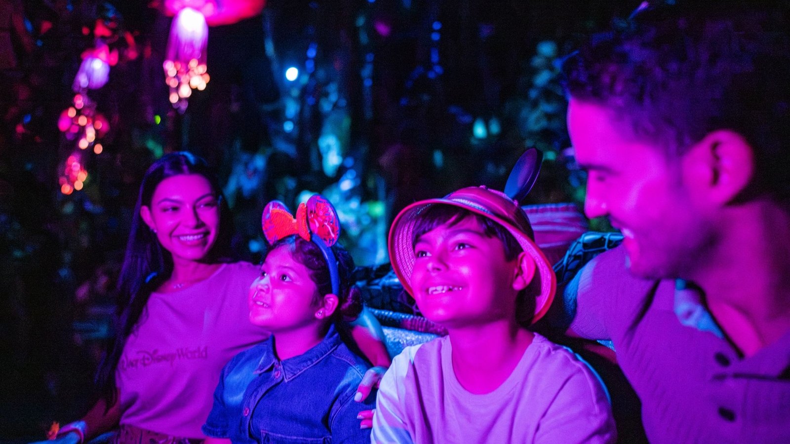 A family of 4 smiling while traveling through the Navi River Journey attraction in Disney’s Animal Kingdom theme park