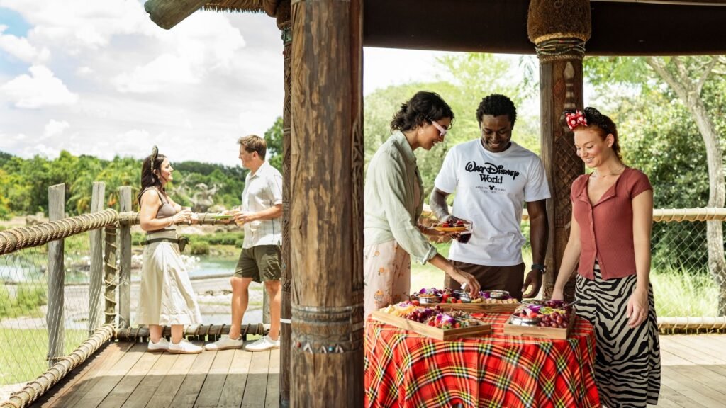 Guests socializing around a table of snacks at a patio in Harambe Wildlife Preserve